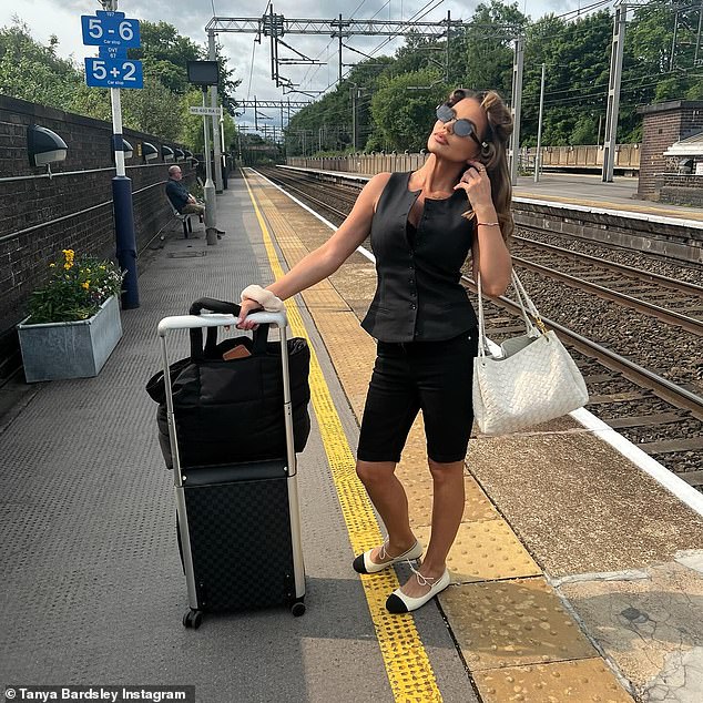 The Real Housewives of Cheshire star cut a stylish figure in a black waistcoat from Because of Alice and Matalan bike shorts as she stood on the train platform