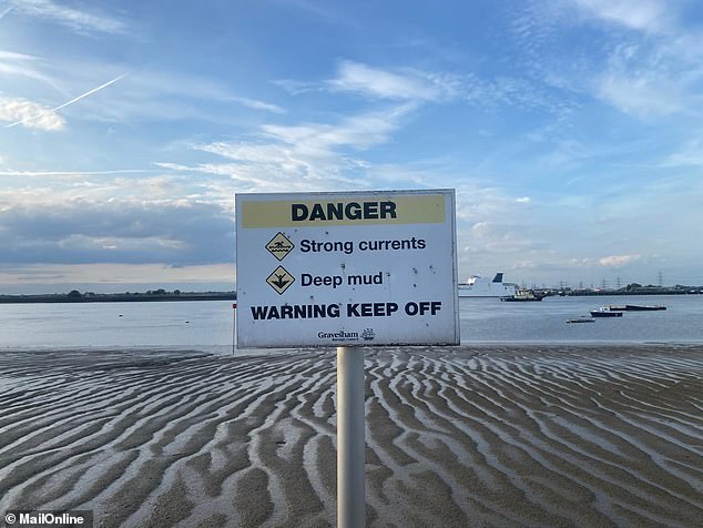 Warning signs reading 'DANGER. Strong currents. Deep mud. WARNING KEEP OFF' are posted every 40ft along the promenade edge