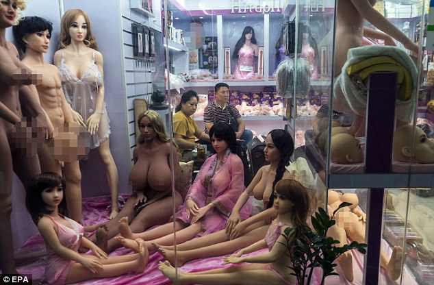 Disturbing images give an insight into China's strange sex robot factory where people can order custom-made AI dolls, some of which are the size of children. Pictured is a vendor and costumer in the shop in Guangzhou Adult Market in Guangzhou