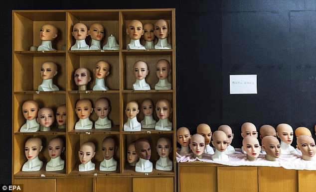 A worker hangs dolls' bodies to dry and checks them in sex dolls factory in Dongguan