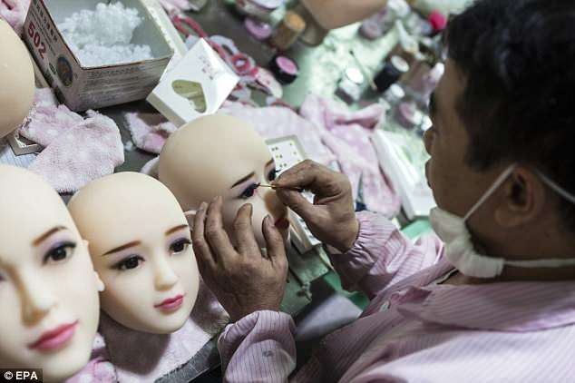 A worker paints make-up on dolls' faces in sex dolls factory in Dongguan, Guandong Province