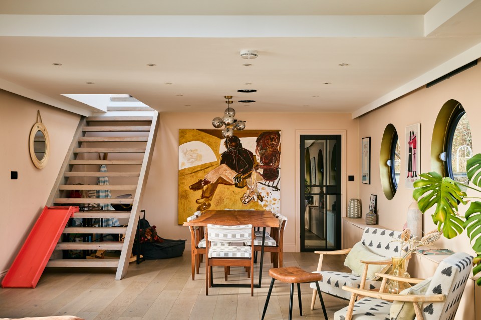 Interior view of a houseboat's living area, featuring a dining table, chairs, and a staircase.