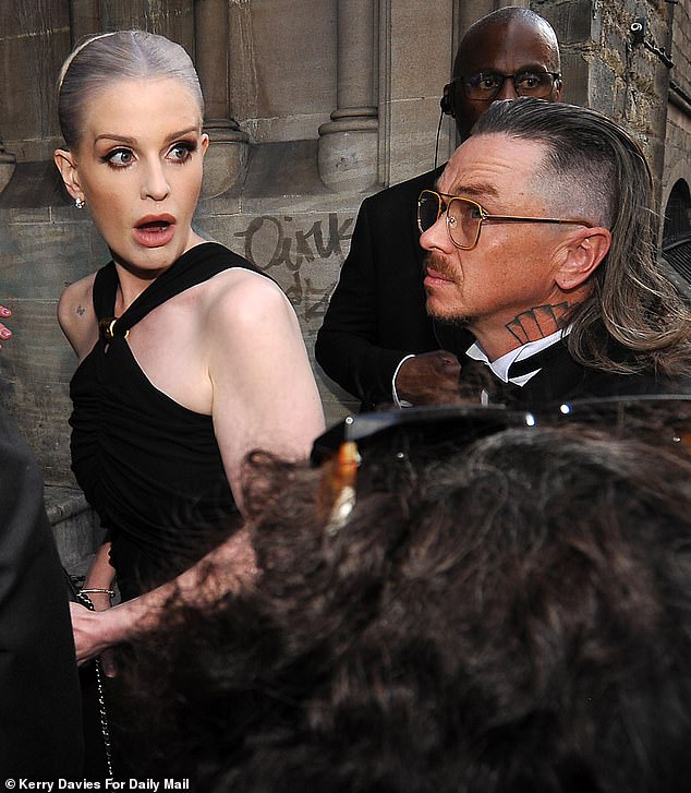 The American TV personality, 40, stepped out at the Welsh Chapel in London on Saturday in a figure hugging black gown, which featured a gold fitting and cross over straps