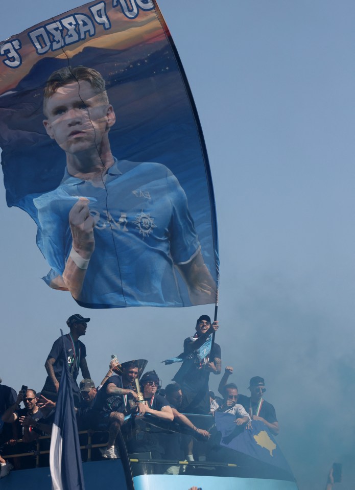 Scott McTominay and Matteo Politano celebrating on a victory parade bus in Naples.