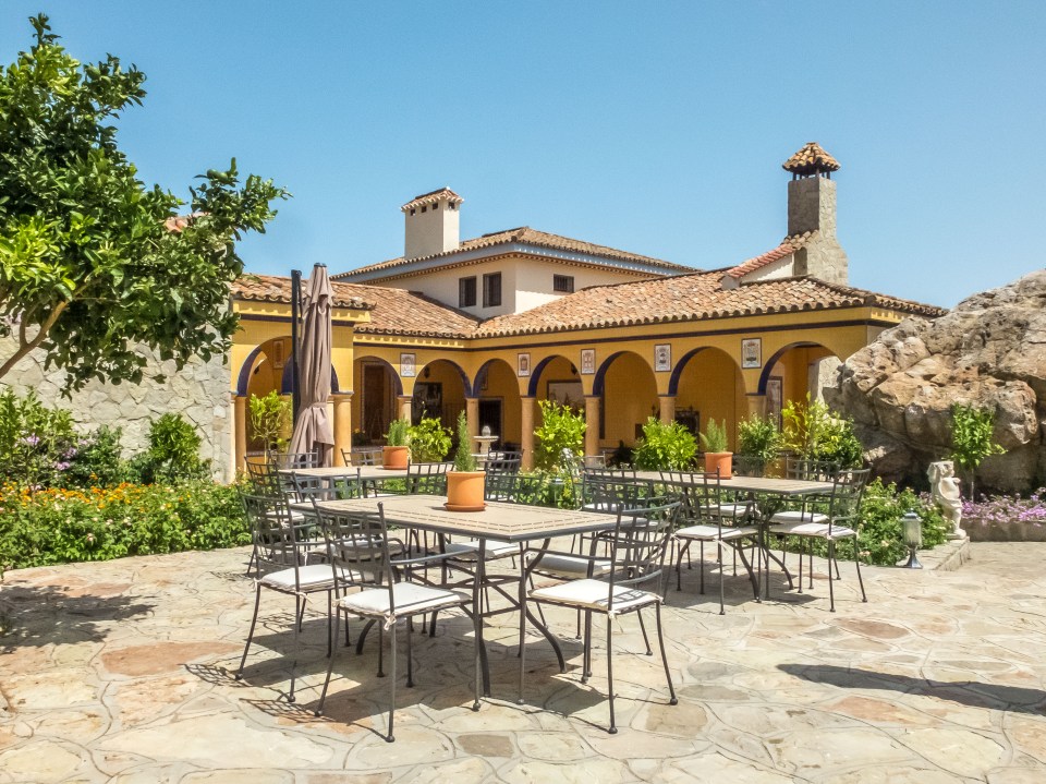 Patio furniture in front of a yellow building.