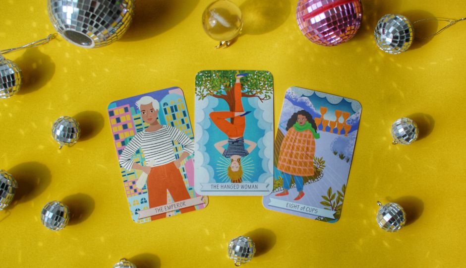 Illustration of three tarot cards (The Emperor, The Hanged Woman, Eight of Cups) surrounded by disco balls.