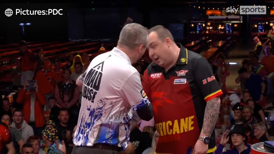 Two darts players arguing on stage.