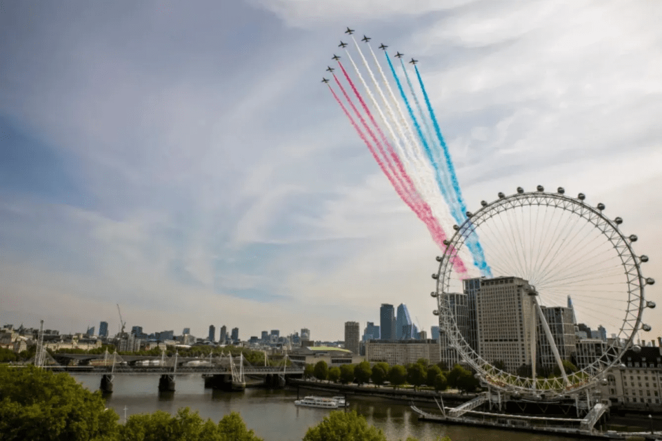 Jets leaving red, white, and blue smoke trails over the London Eye.