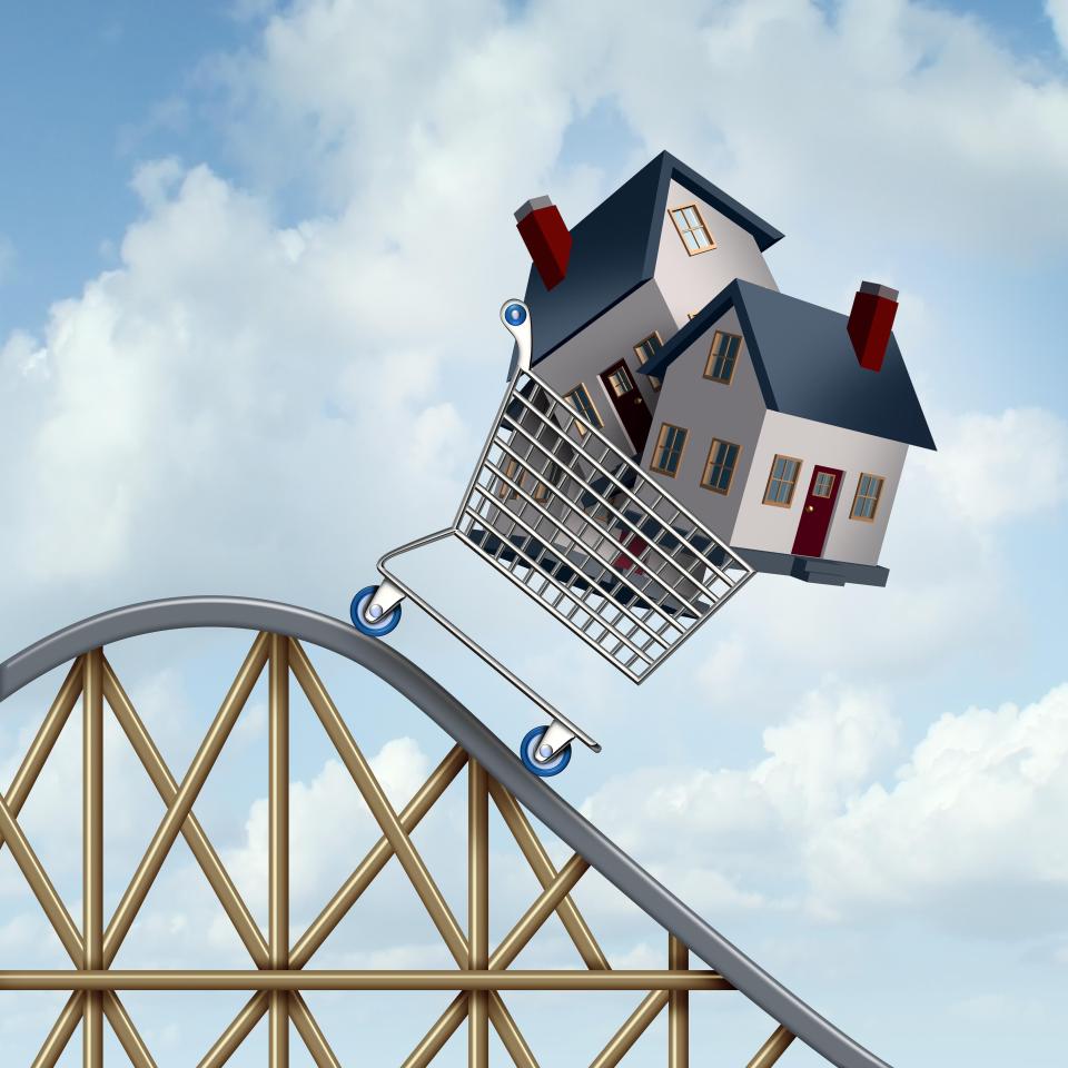 Illustration of a house in a shopping cart going down a roller coaster, representing falling home prices.