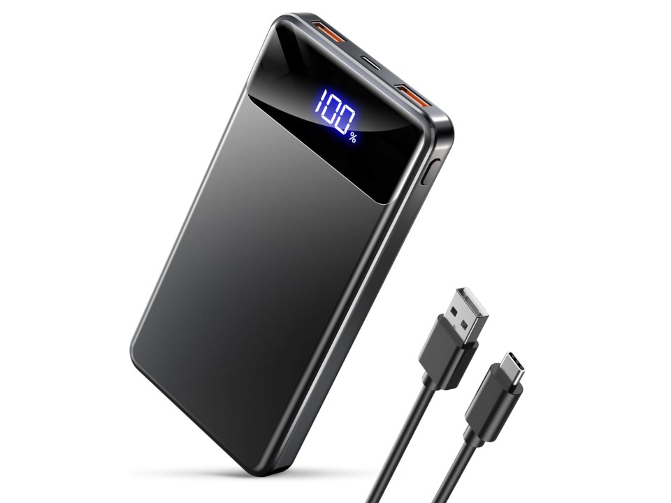 Black portable charger with a digital display showing 100% charge and a USB cable.