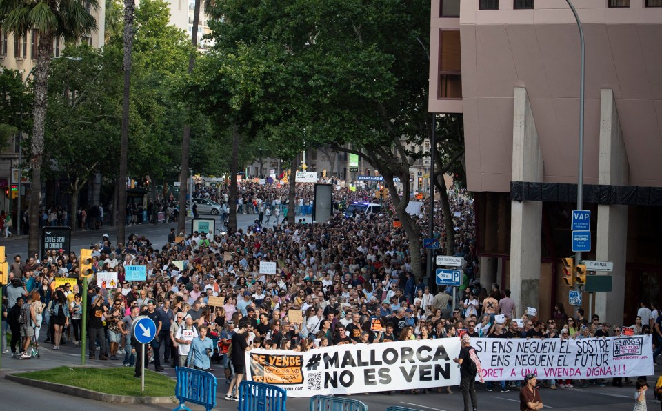 Protestors in Palma de Mallorca holding banners that read “Mallorca is not for sale” and “If they deny us housing, they deny us the future. Right to decent housing!!!”