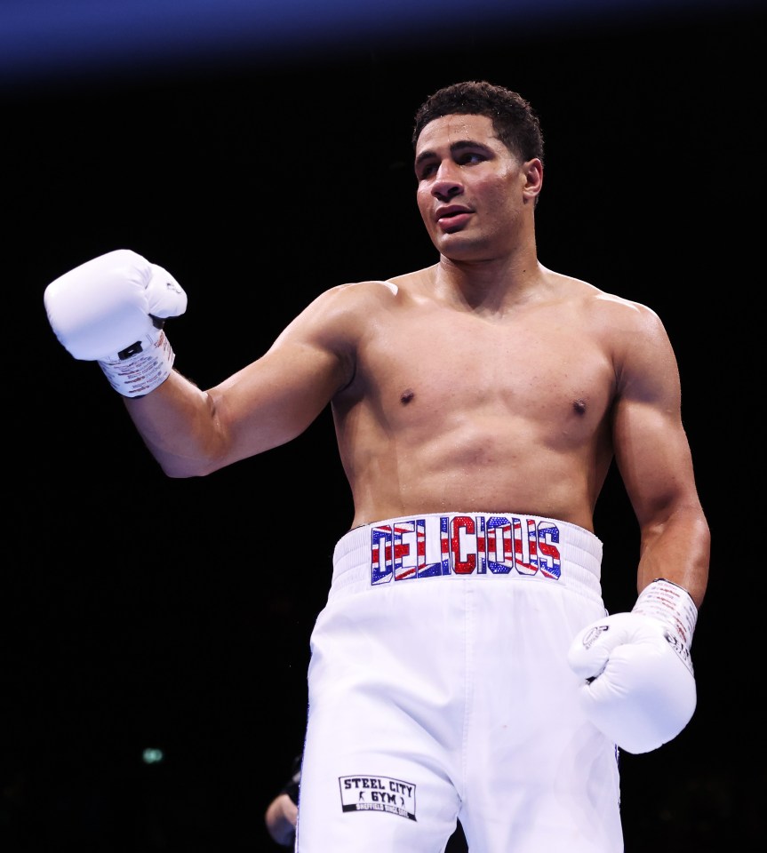 Delicious Orie, a boxer, raises his fist after a heavyweight fight.