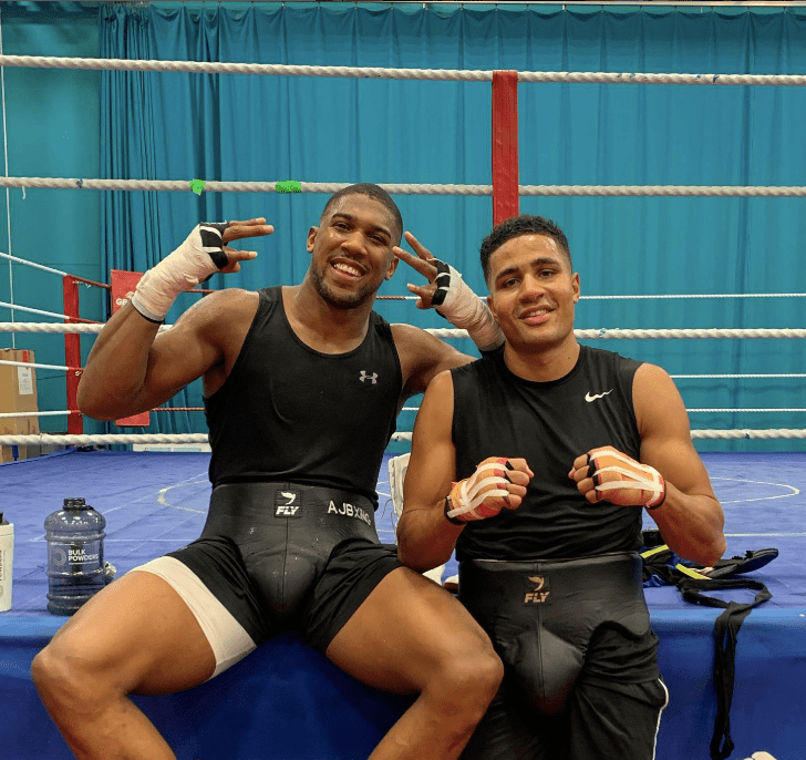 Two boxers posing in a boxing ring.