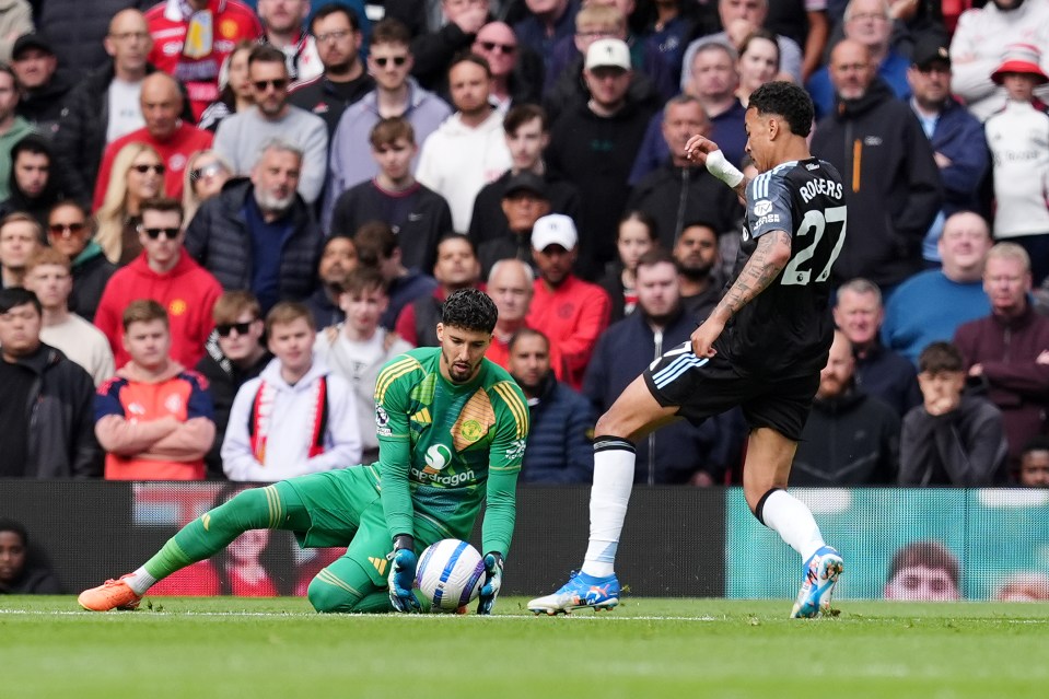 Aston Villa's Morgan Rogers kicks the ball away from Manchester United's goalkeeper.