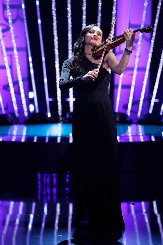 A woman in a black dress playing a violin on stage at the BAFTA Television Awards.
