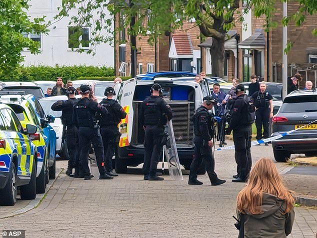 Police stand outside a police van containing an out of control dog after it attacked a baby and two adults