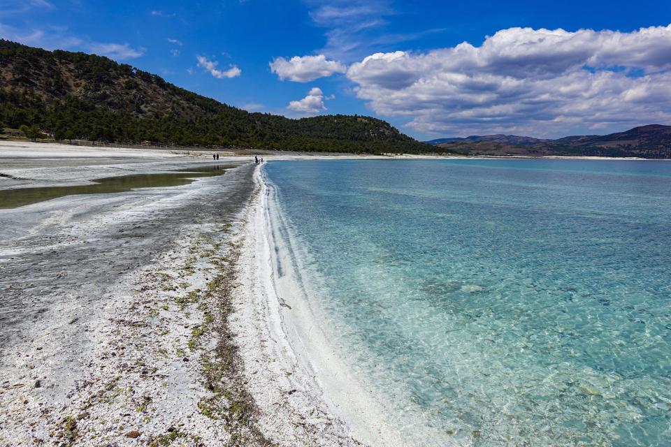 Lake Salda in Turkey, with clear turquoise water and white sandy shore.