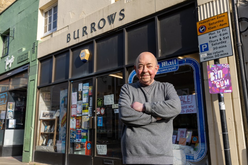 A man stands outside Burrows newsagents, which is closing after 125 years.