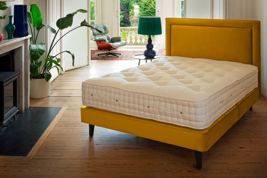 Hypnos Legacy Origins III mattress on a mustard yellow bed frame.