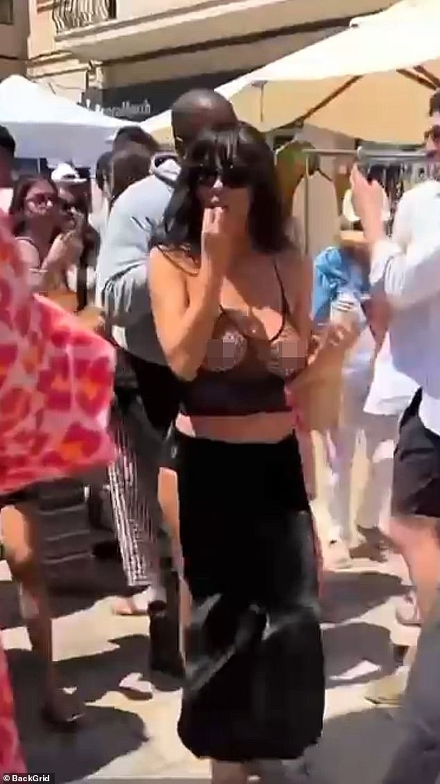 Bianca Censori has angered locals after baring her breasts in a fish net bra during a shopping trip with husband Kanye West in Spain on Saturday