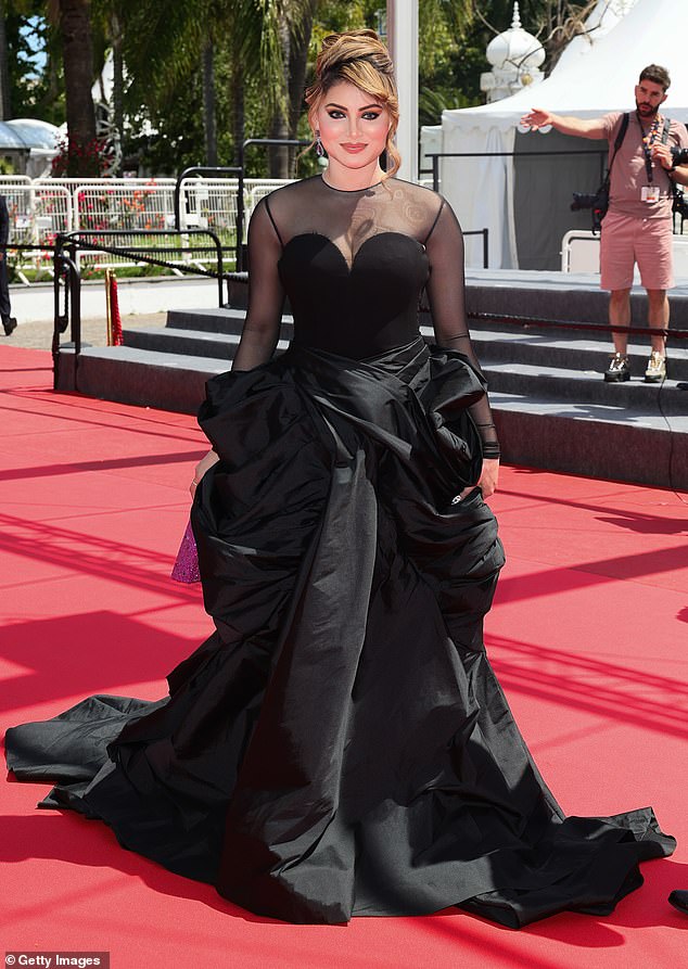 Urvashi Rautela (pictured) looked stunning on the red carpet in a black gown - but eagle-eyed fans noticed a tear in her gown