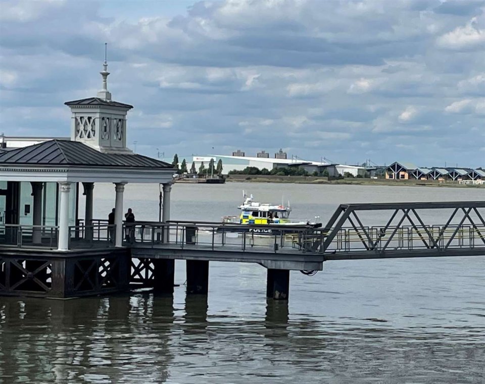 Police officers on a boat searching the Thames River.