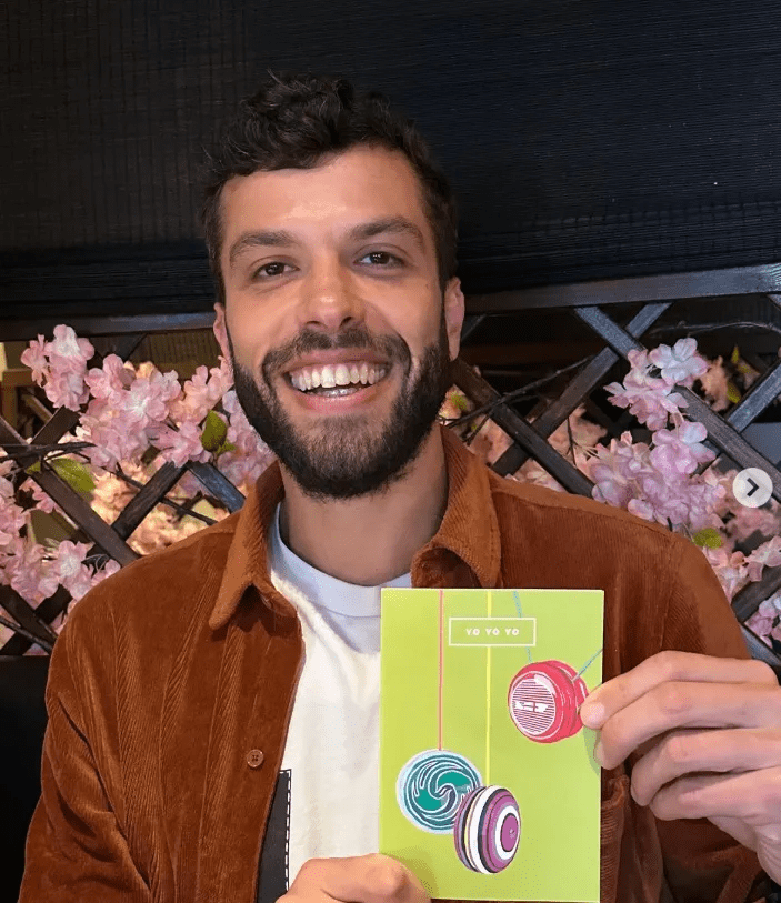 Man holding a yo-yo themed card.