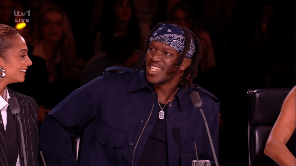 Screenshot of KSI smiling on a judging panel.