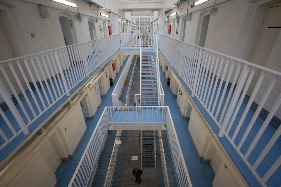 High-angle view of a prison's interior, showing multiple cell blocks and walkways.