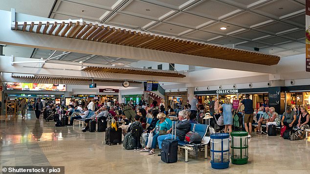 Travellers are photographed while waiting inside Lanzarote airport. Some 800,000 passengers moved through the hub in March alone this year