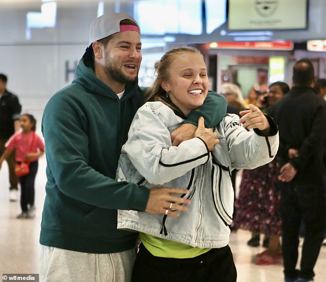 Chris Hughes sweetly welcomed his love interest JoJo Siwa back to the UK from her brief trip to LA as he picked her up from Heathrow airport with a bunch of red roses on Sunday