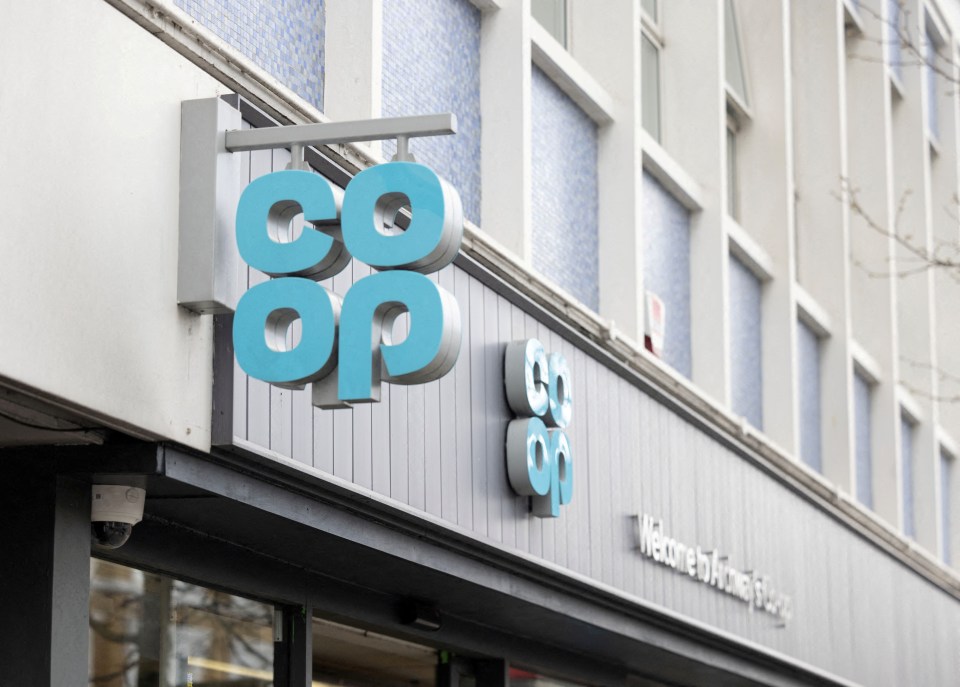 a blue co op sign hangs on a brick wall