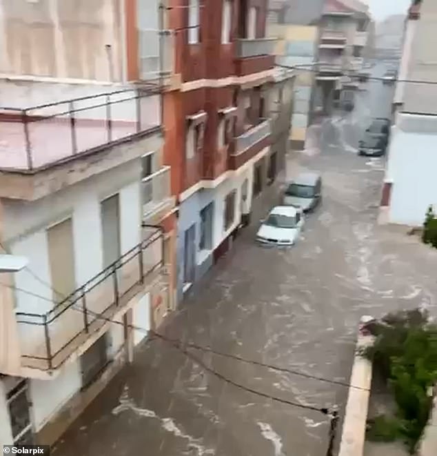 A freak hail and rain storm has struck southern Spain , leaving renowned tourist hotspots covered in ice and overrun with flood waters