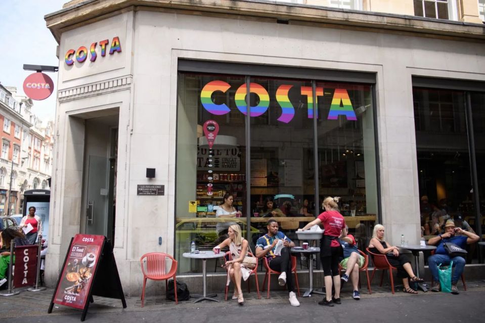 Costa Coffee shop with rainbow logo; people sitting outside.