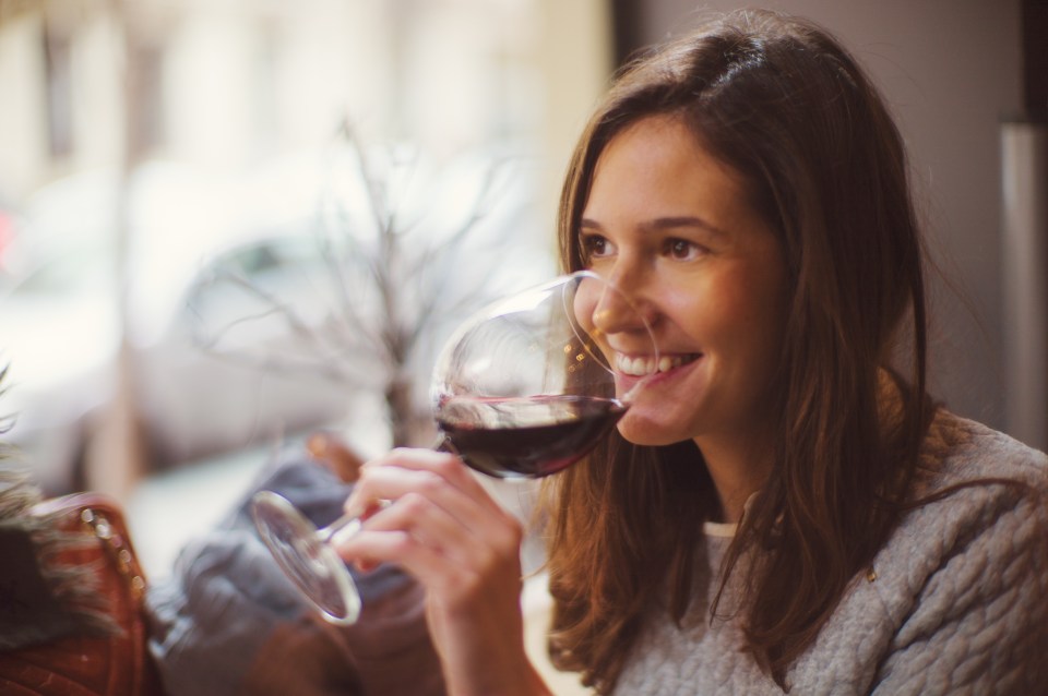 Woman enjoying a glass of red wine.