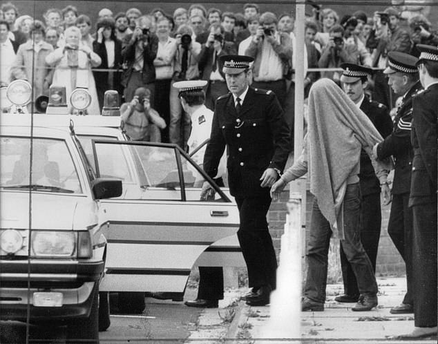 Fairley with his head under a blanket being led away by police after being arrested