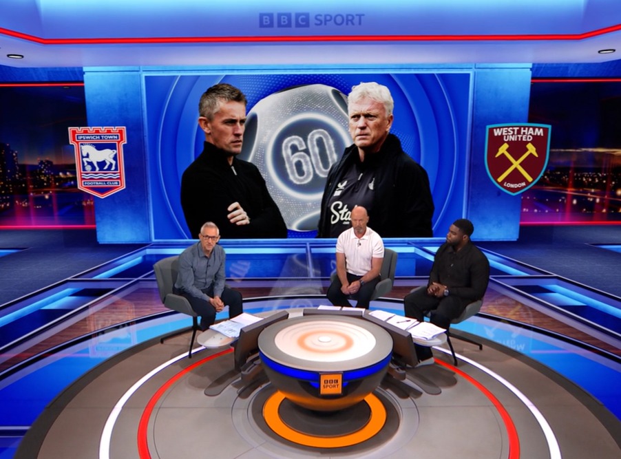 Three men sitting around a table on a BBC Sport set, with a large screen showing images of two soccer coaches and team logos.