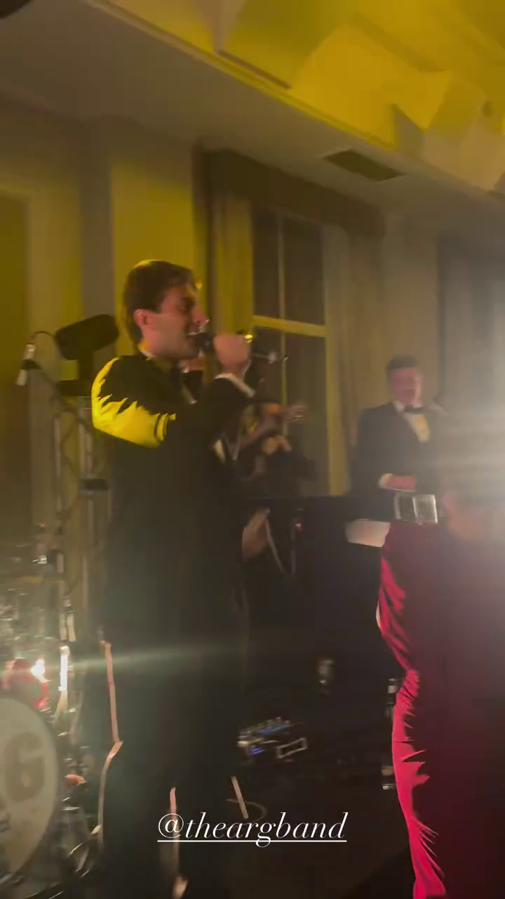 James Argent singing on stage with a band.