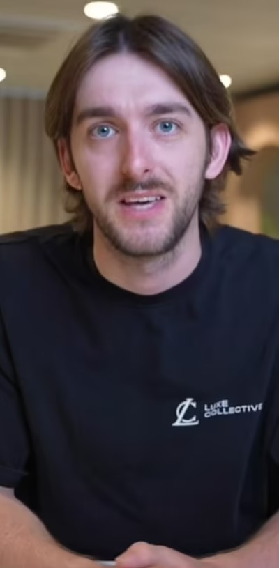 Man with shoulder-length brown hair wearing a black Luke Collective shirt.