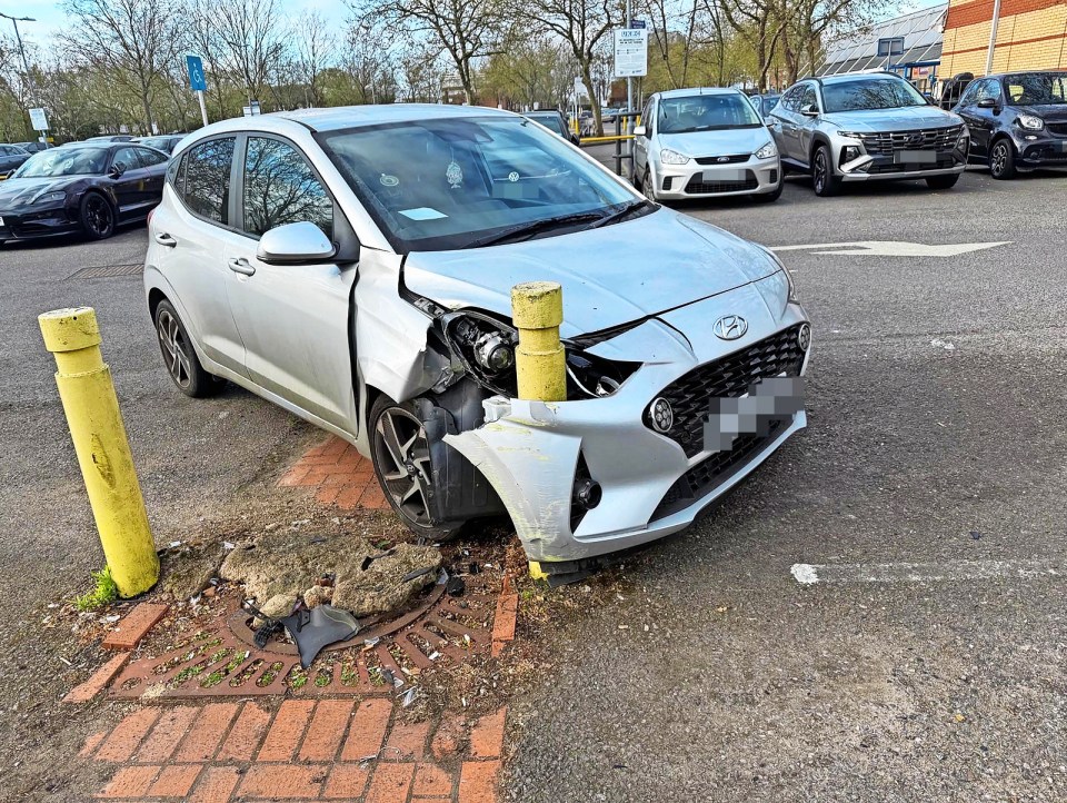 Silver car damaged in parking lot accident.