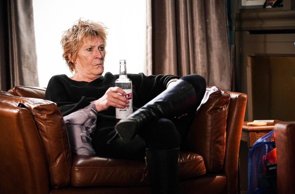 Linda Henry as Shirley Carter in EastEnders holding a bottle of vodka.