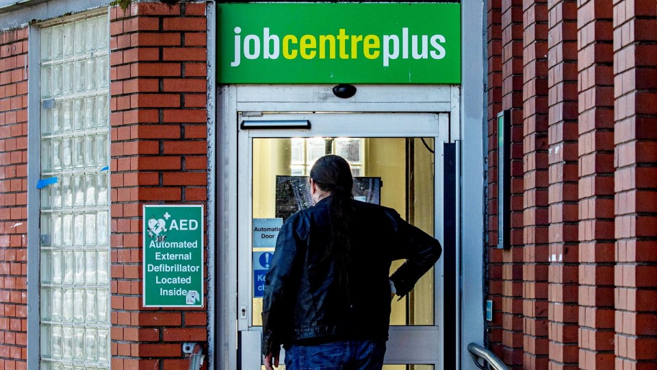 Person standing outside a Jobcentre Plus building.