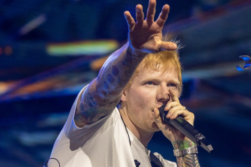 Ed Sheeran performing at Coachella, playing an acoustic guitar.