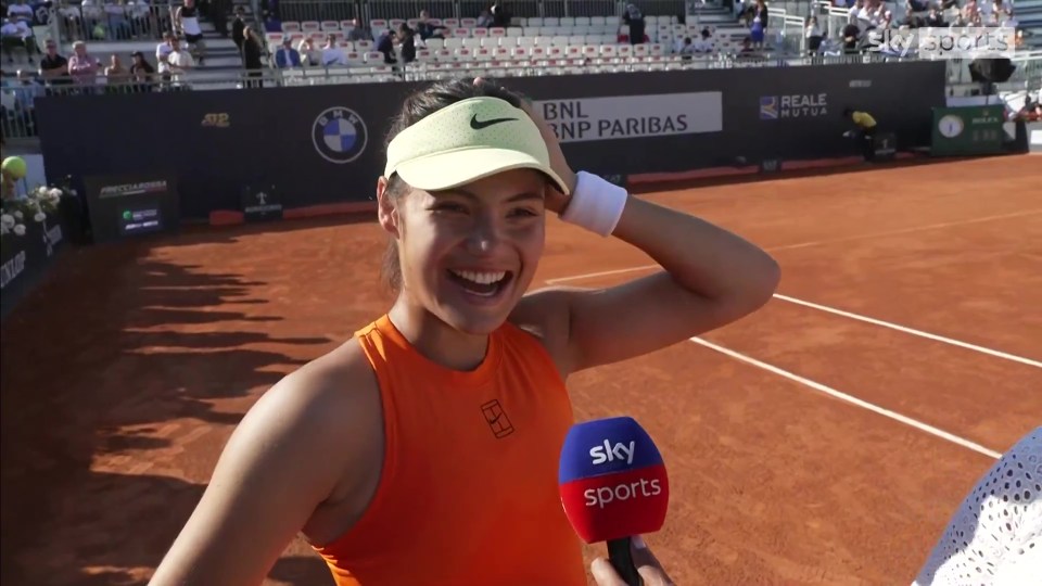 Smiling tennis player being interviewed on a court.