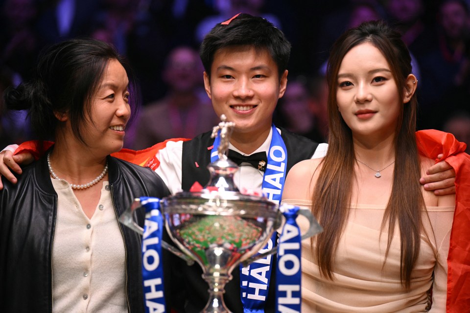 Zhao Xintong with trophy and companions after winning the World Snooker Championship.