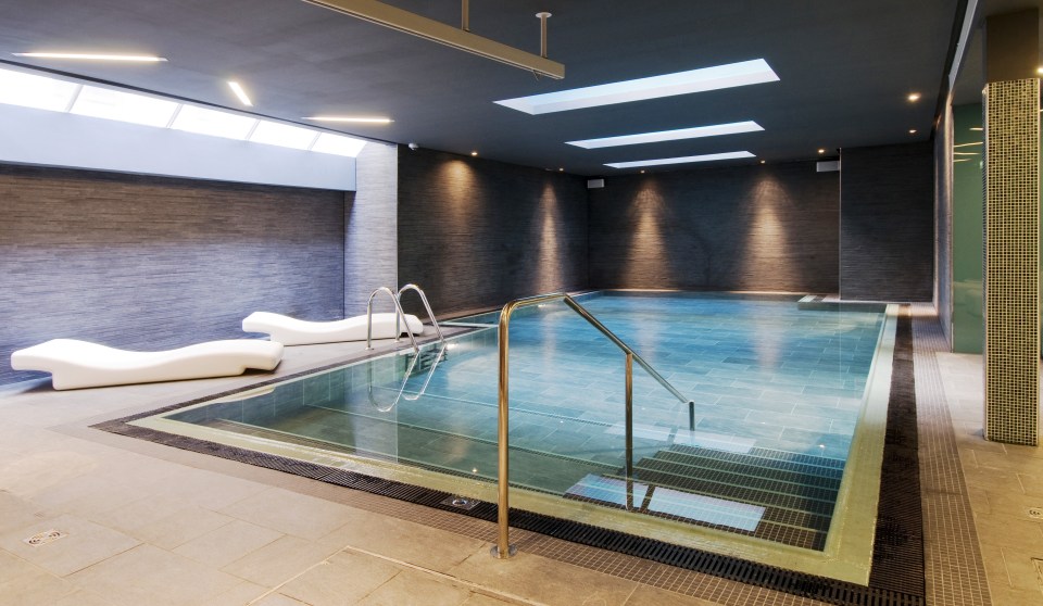 Indoor swimming pool with lounge chairs.