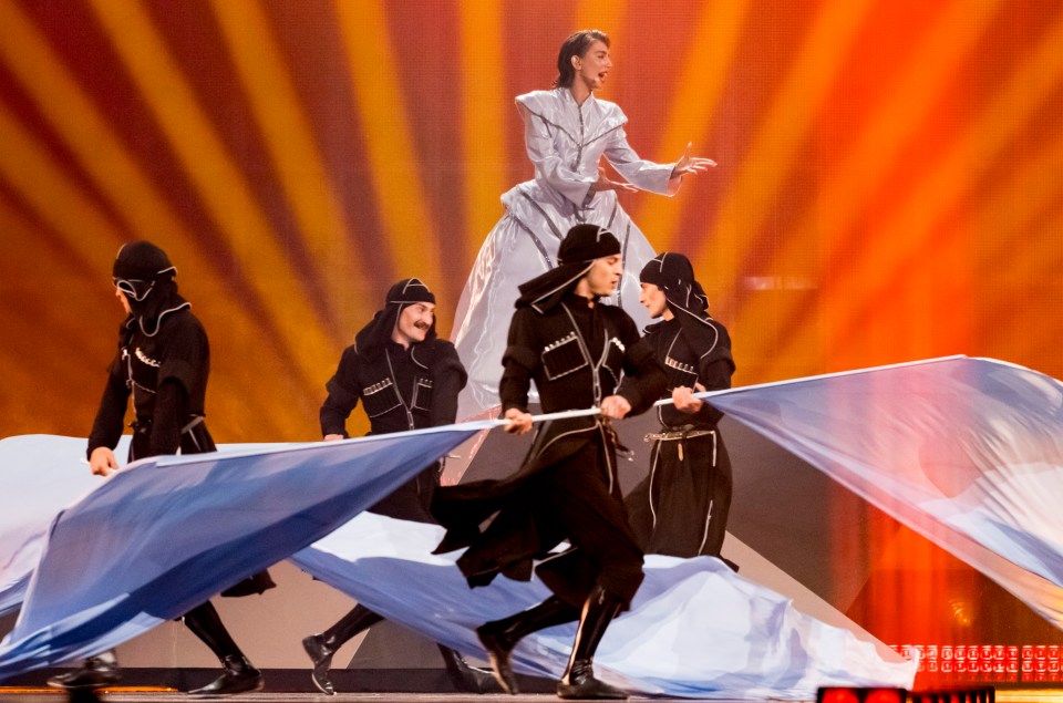 A singer and dancers performing on stage at the Eurovision Song Contest.