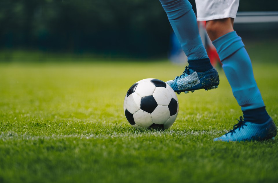 Close-up of a soccer player's legs and feet dribbling the ball.