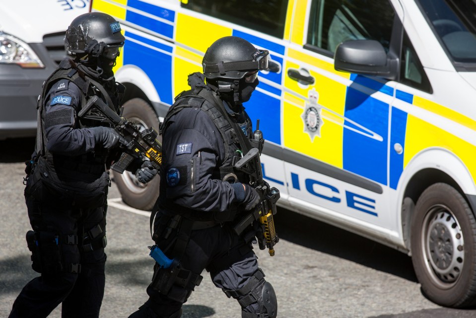 Two armed police officers in tactical gear during a training exercise.