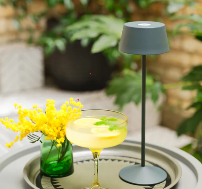 Rechargeable lamp and cocktail on a tray.